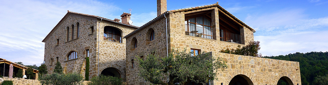 Cascina in sassi, con un giardino di erba e ulivi
