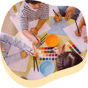 un gruppetto di bambini mentre disegnano e colorano con gli acquerelli