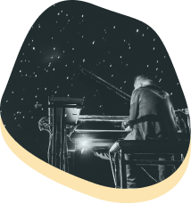 ragazzo mentre suona il pianoforte sotto le stelle