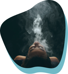 ragazza avvolta dalla nube di fumo di una candela profumata