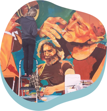 un signore mentre dipinge un murales