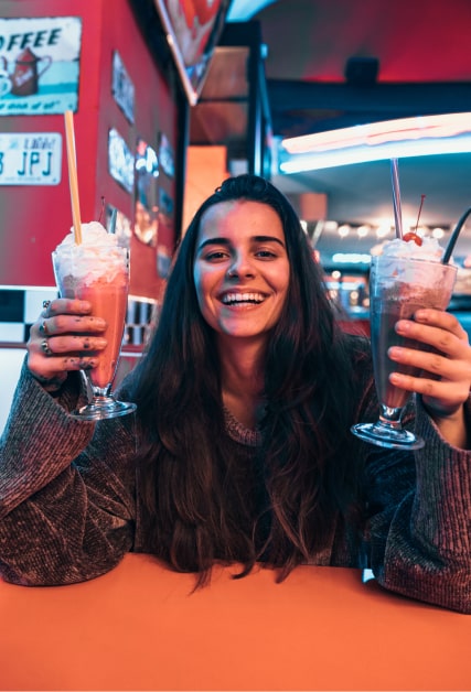 Ragazza tiene in mano due milkshake